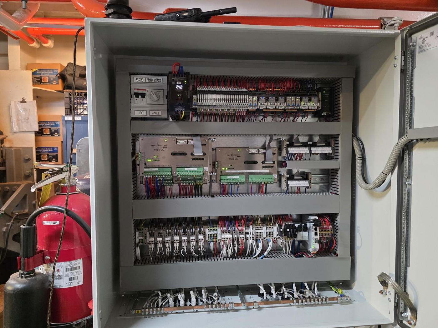 CANbus PLC cabinet installed in engine room — door open showing breakers, PLC multi-I/O modules, and terminal strips